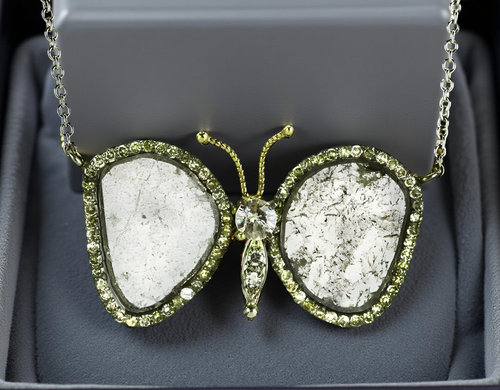 This Diamond Slices Butterfly Necklace features raw diamond slices framed by 5.12 carats of round diamonds, set in fine silver and 18K white gold. A graceful yet powerful piece that blends natural texture with refined sparkle.