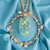 Show-stopping boulder opal pendant surrounded by sapphires and diamonds in 18K yellow gold.