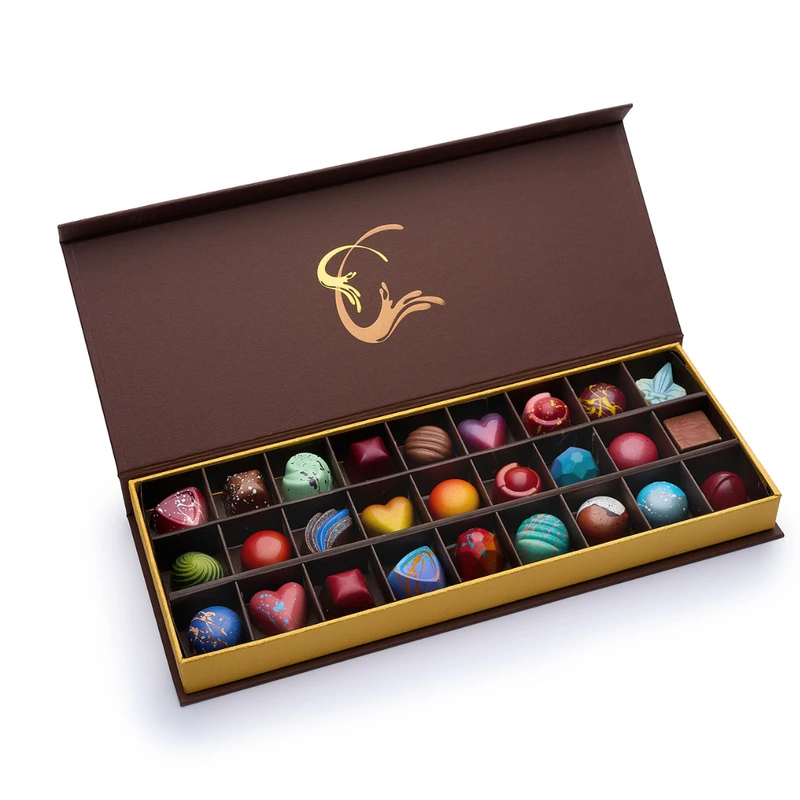 An open Infusion Chocolates gift box with a gold-foil logo, filled with 27 hand-painted truffles