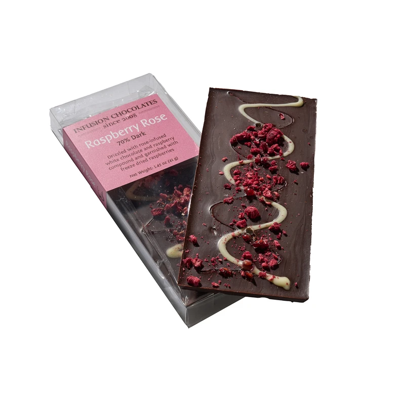 A Raspberry Rose infusion bar topped with freeze-dried raspberries, beside its box