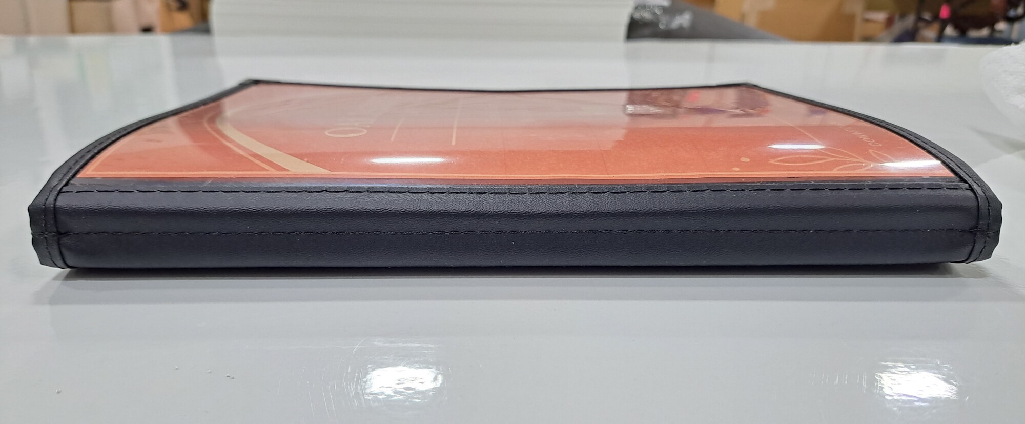 Close-up of stitched leatherette binding on heavy-duty restaurant menu cover