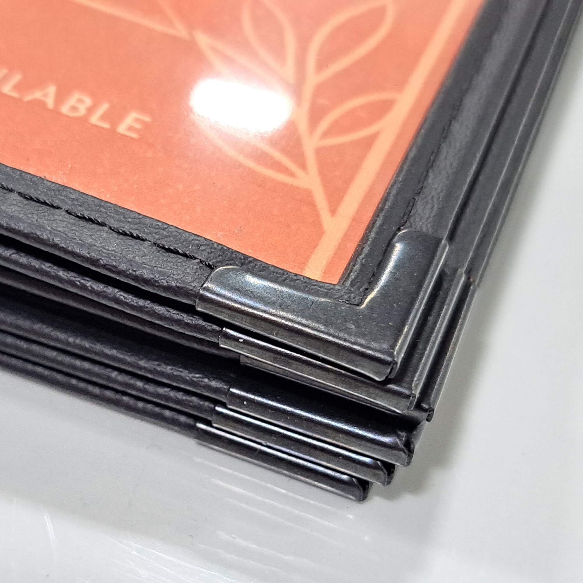 Metal corner protector detail on leatherette restaurant menu cover