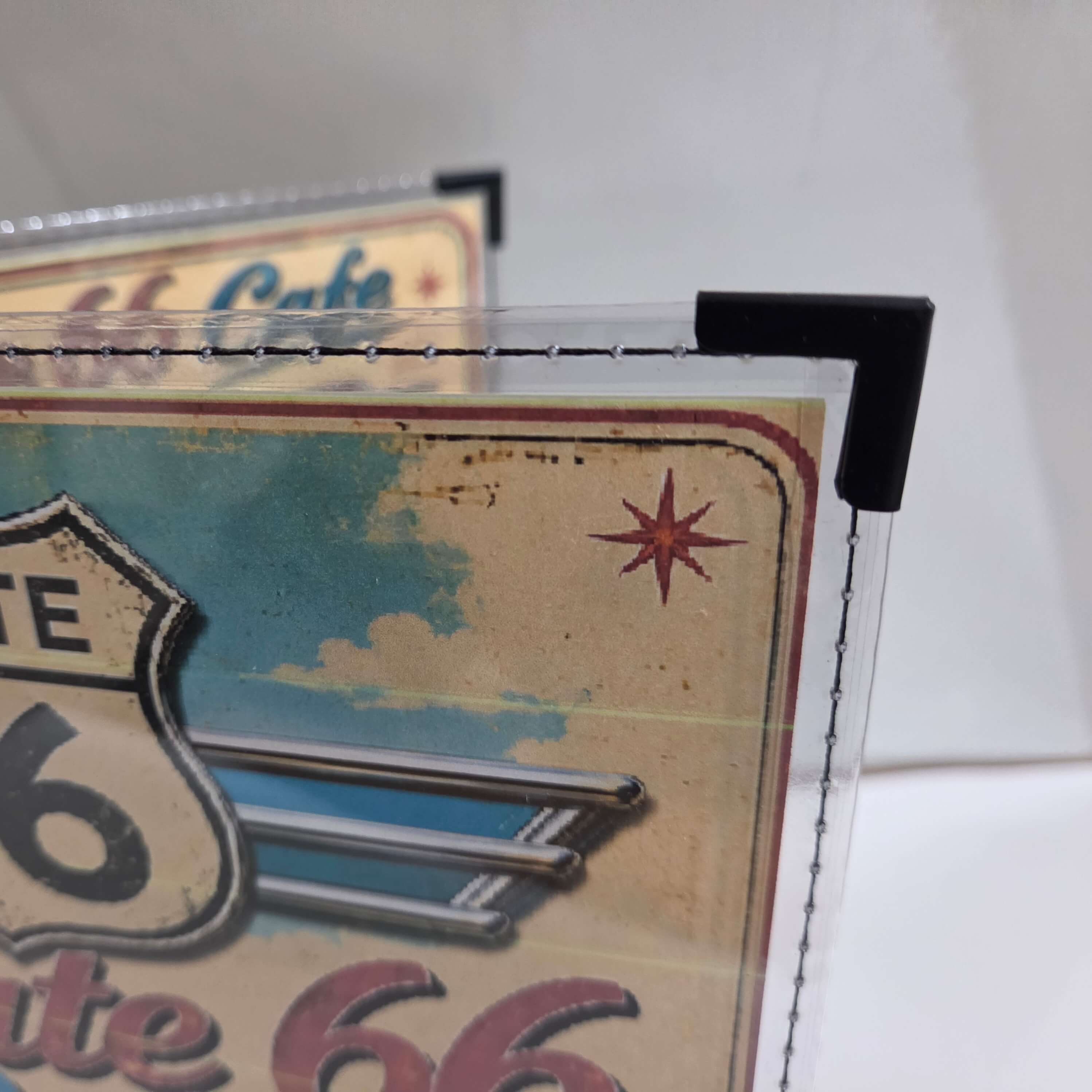 Close-up of the clear trim, contrasting stitched border and metal corner on a Route 66 Cafe Menu Cover