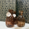5" amber glass bud vase with a warm vintage-inspired finish, perfect for displaying single stems or adding a cozy farmhouse touch to any space.