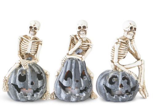Assorted 5.5 Inch Resin Skeletons Sitting on Gray LED Jack O Lantern