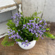 PURPLE FLOWERS IN WHITE CERAMIC POT