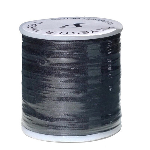 A brand new reel of black polyester thread wrapped in clear plastic