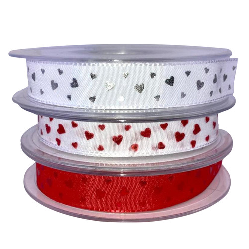 15mm satin ribbon with tiny embroidered hearts, image shows three colours. white with silver hearts at the top of the stack. Middle ribbon roll is white satin ribbon with red hearts and the bottom spool is red satin ribbon with red hearts.