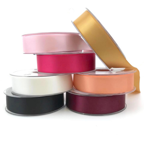 Seven reels of double satin ribbon, 25mm wide and 20 metres long, shown in a smooth satin finish. Pink, gold, Cerise, Peach, White, Black and Wine.