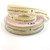 Image shows a cream-beige grosgrain ribbon printed on one side with the phrase “Happy Birthday” and small balloon motifs between each repeat. The ribbon is 16mm wide and has a vintage-style look, shown wound around a spool.
