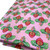 Image shows a medium weight dark pink cotton fabric, 137cm wide, printed with a colourful floral design featuring large flowers and leafy shapes resembling cabbage leaves. The design is uniform with no set direction. Folded in a rectangle shown at an angle.