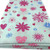 Image shows a mint green polycotton fabric printed with a repeating pattern of varying sizes of  hearts circles and flowers in soft, summery shades of pink and blue. The fabric is 112cm wide with a smooth texture and lightweight feel. Folded in a rectangle.