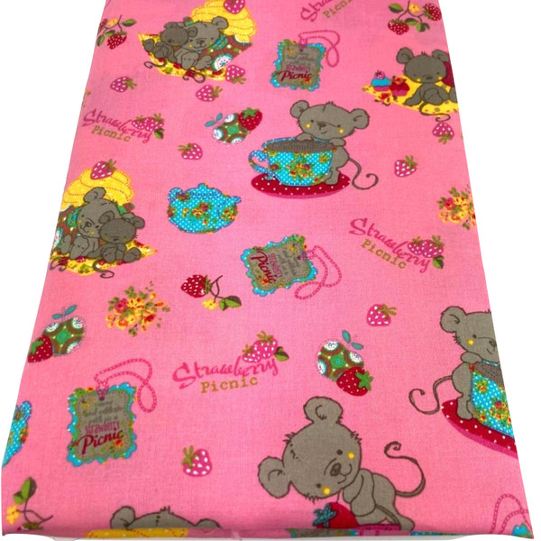 Image shows a lightweight pink cotton fabric, 142cm wide, printed with a whimsical picnic-themed design featuring mice, teapots, and strawberries. The fabric has a smooth finish and soft drape and is shown folded into a rectangle.