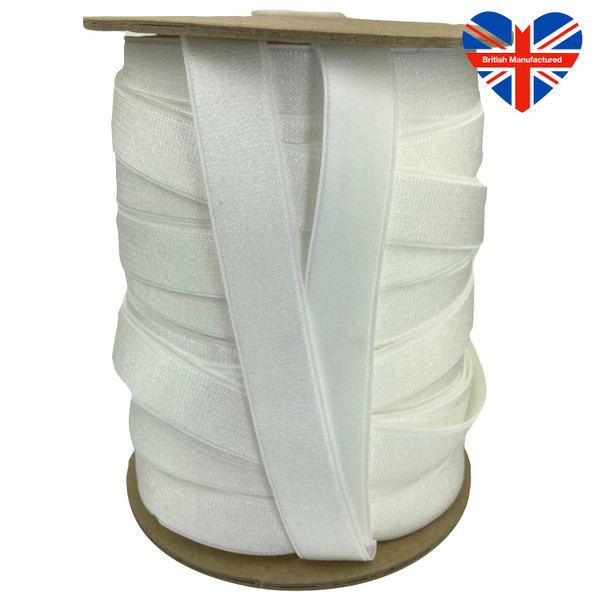 Image shows a roll of 19mm wide white soft elastic ribbon. The front has a smooth satin sheen, while the reverse features a plush texture for comfort against the skin. There is a union jack heart in the top right corner advising this is a British manufactured product.