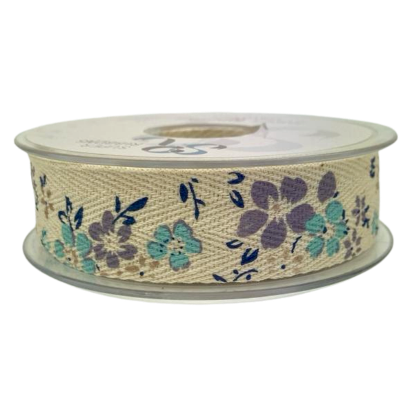 A spool of cream coloured woven ribbon tape with a printed pattern of blue and lilac and beige flowers and navy leaves