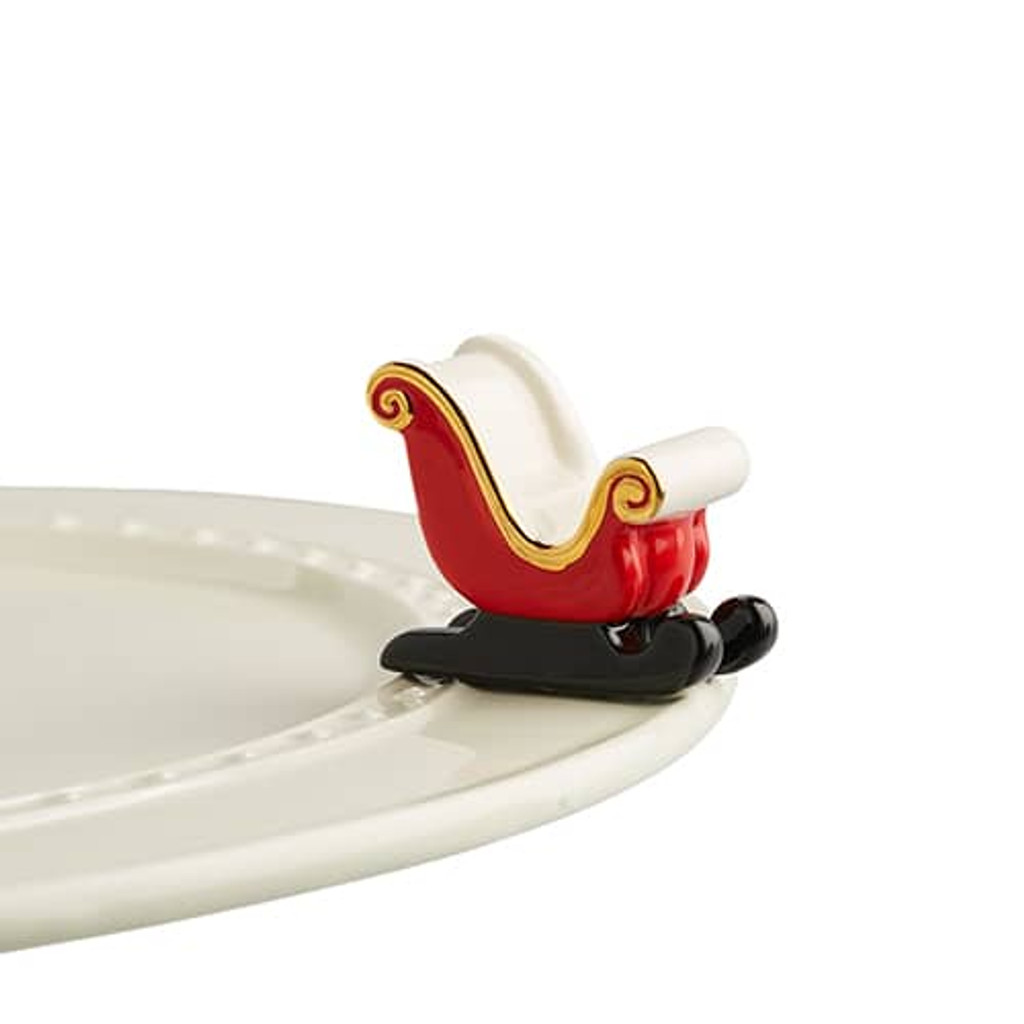 Nora Fleming sleigh bells ring,A198
Sleigh bells ring, are you listening!? Santa clause is coming to town with a red sleigh mini to spread holiday cheer for you and your guests. Not dishwasher safe, hand wash only.
