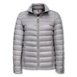 A light grey women's puffer jacket with a zip front and a high collar. It features a logo on the chest. A light grey women's puffer jacket with a zip front and a high collar. It features a logo on the chest.