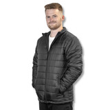 A unisex black puffer jacket with a zip front and pockets worn by a model against a plain background. A unisex black puffer jacket with a zip front and pockets worn by a model against a plain background.