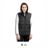 A woman stands wearing a black puffer vest over a white long-sleeve top. The vest features a zip front and has a logo. A woman stands wearing a black puffer vest over a white long-sleeve top. The vest features a zip front and has a logo.