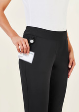 A pair of black women's 3/4 length stretch pants with a pocket, shown being held by a model.