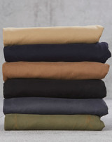 A stack of folded chino pants in various colours: beige, navy, brown, black, dark grey, and olive green.