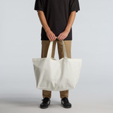 An oversized tote bag in off-white held by a person, featuring strong handles and a simple design. An oversized tote bag in off-white held by a person, featuring strong handles and a simple design.