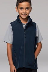 A boy smiles while wearing a navy blue kids' vest with zippered pockets and a standing collar.