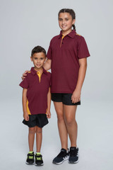 Two children wearing maroon and yellow polo shirts, standing side by side, with one in a larger size than the other.