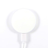A circular, magnetic wireless charger with a white surface and a white cable attached.