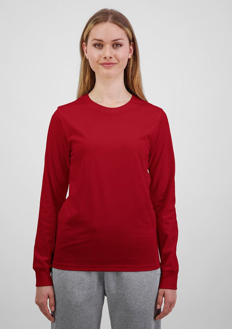 A long sleeve women's tee in bright red, displayed by a model in grey trousers, featuring a logo.