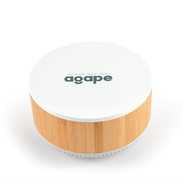 A round speaker and wireless charger in white and bamboo, featuring a logo on the top. A round speaker and wireless charger in white and bamboo, featuring a logo on the top.
