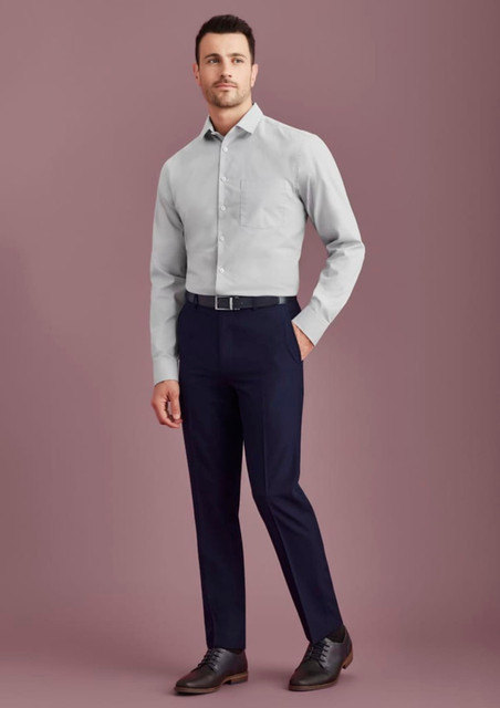 Men's slim fit flat front pants in navy, paired with a light grey shirt and black shoes. Features a logo on the waistband.