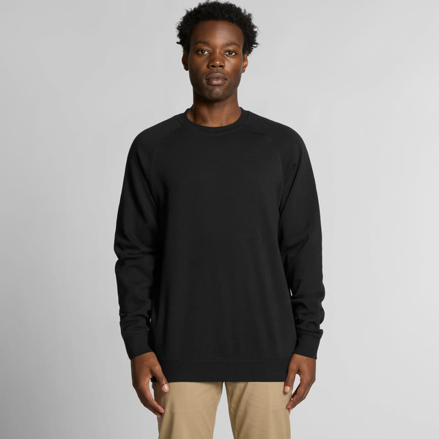 A black jumper is worn by a model with short, curly hair against a neutral background. The garment has a simple design and a logo.