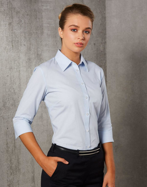 A light blue women's button-up shirt with 3/4 sleeves and a fitted design, featuring a logo on the chest.