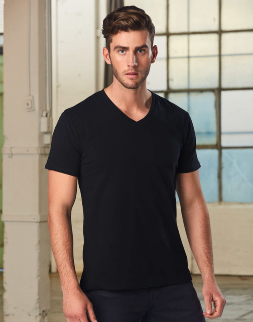 A men's black V-neck short sleeve tee, displayed on a model with a neutral background and natural lighting.