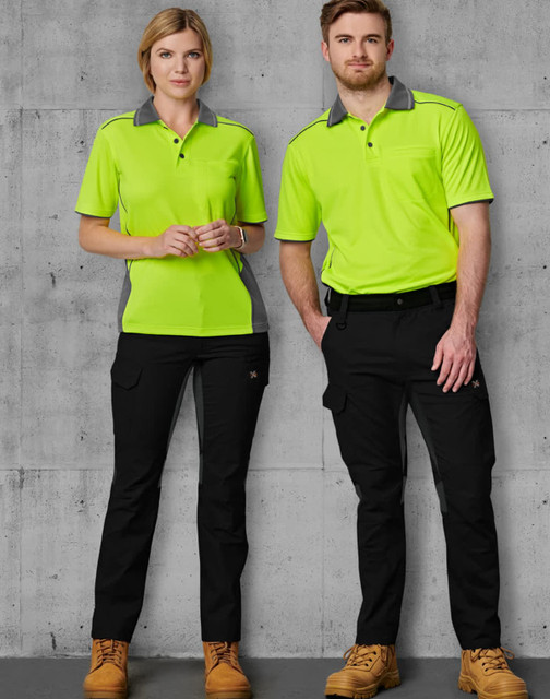 A pair of models wears bright green and grey work shirts with black rip-stop poly/cotton stretch work pants. A pair of models wears bright green and grey work shirts with black rip-stop poly/cotton stretch work pants.