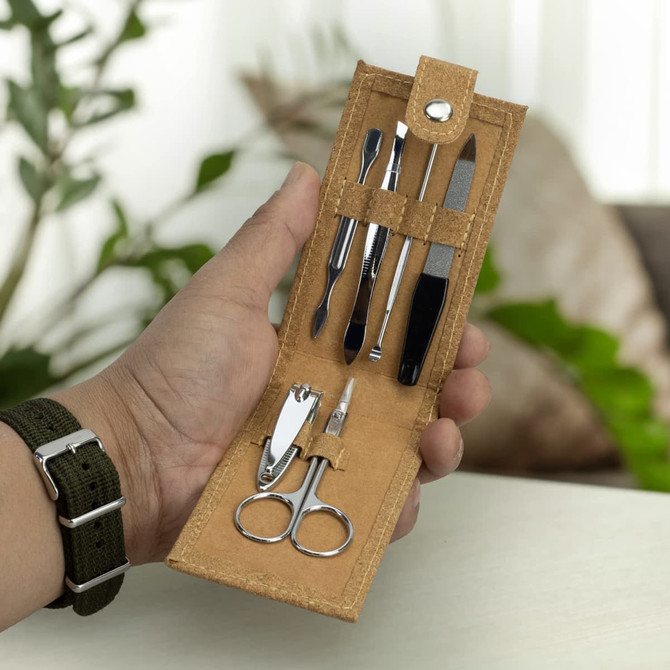 A cork manicure set featuring silver tools including scissors, nail clippers, and a file, housed in a tan pouch.