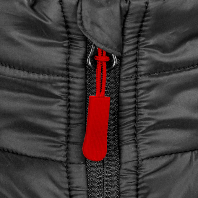 A close-up of a black puffer jacket zipper, featuring a red pull tab and textured fabric. The jacket has a logo.