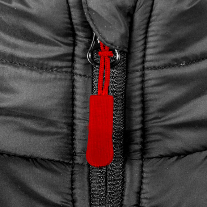 A close-up of a black puffer vest featuring a red zip puller and a central zipper. The material appears insulated.