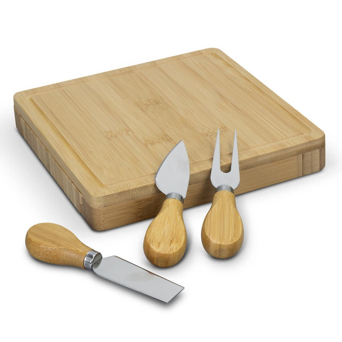 A square bamboo cheese board with three cheese utensils featuring bamboo handles and stainless steel blades.