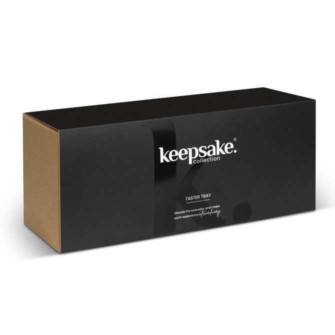 A black and brown box prominently featuring a logo, containing a Keepsake Taster Tray for home use.