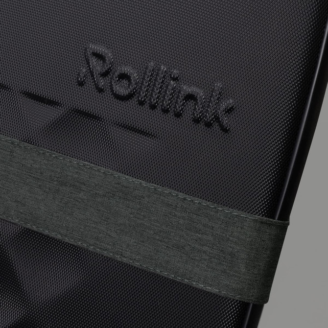 A close-up of a black suitcase featuring a textured surface and an attached dark green strap. It has a logo visible.