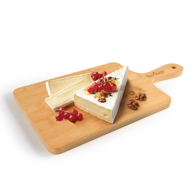 A bamboo serving board with a wedge of brie cheese, garnished with berries and walnuts, featuring a handle.