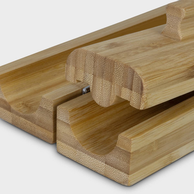 A bamboo sushi maker featuring two interlocking pieces, showcasing a smooth, natural finish. It includes a small handle.