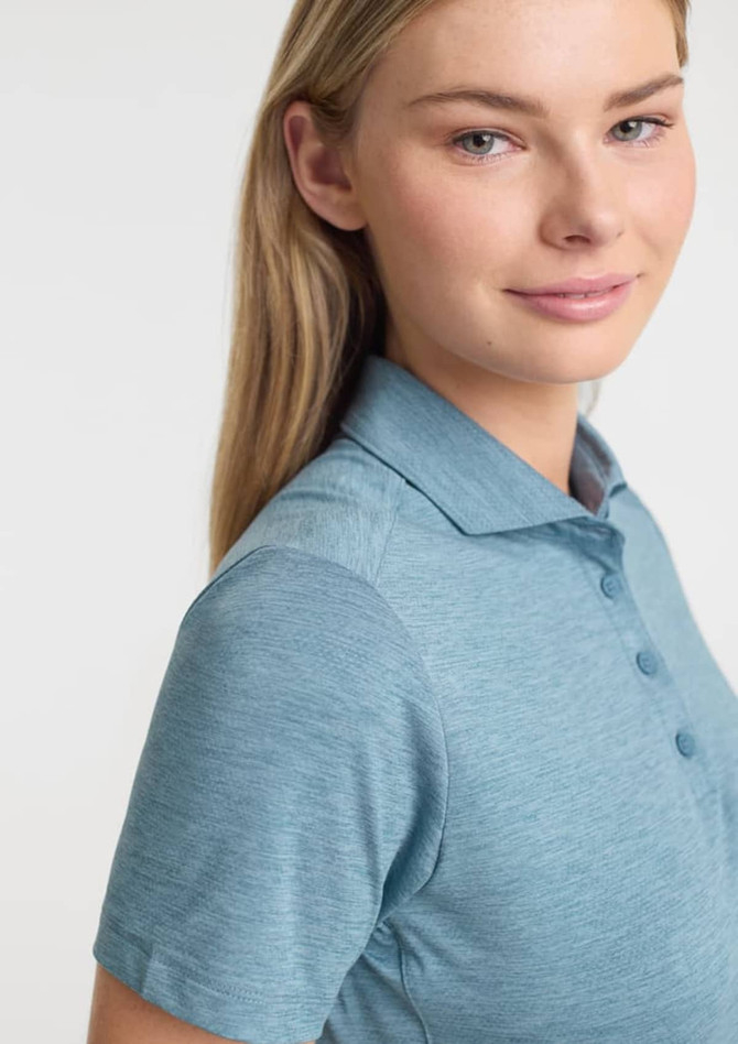 A women's short sleeve polo in a soft blue colour, featuring a collar and buttons, with a logo on the front.