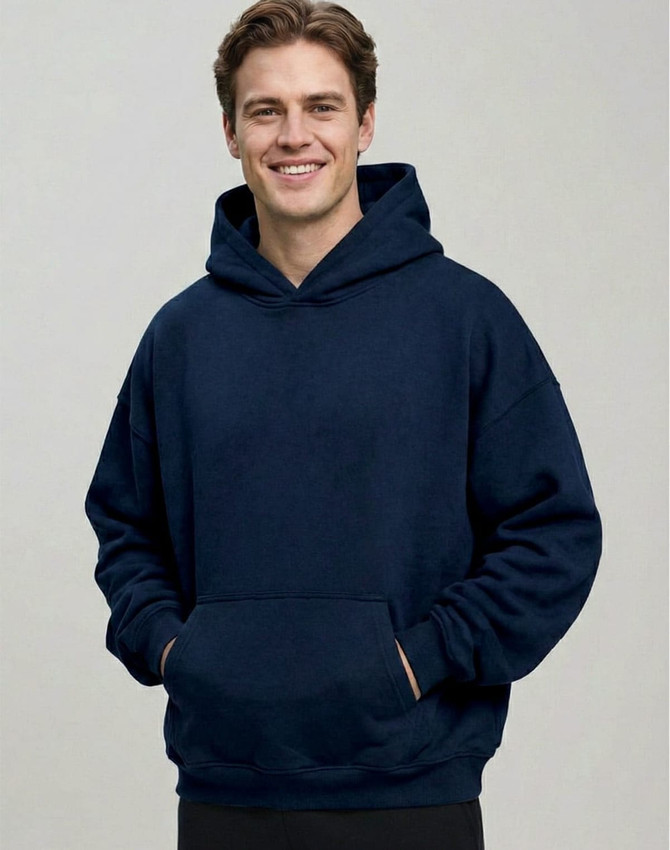 A man wearing a navy unisex premium fleece oversized hoodie with a front pocket and a hood.