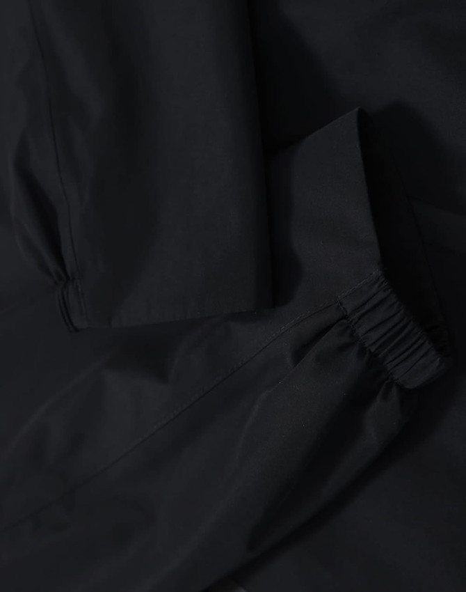 A waterproof jacket in black featuring elasticated cuffs and a durable fabric. The jacket has a logo present.