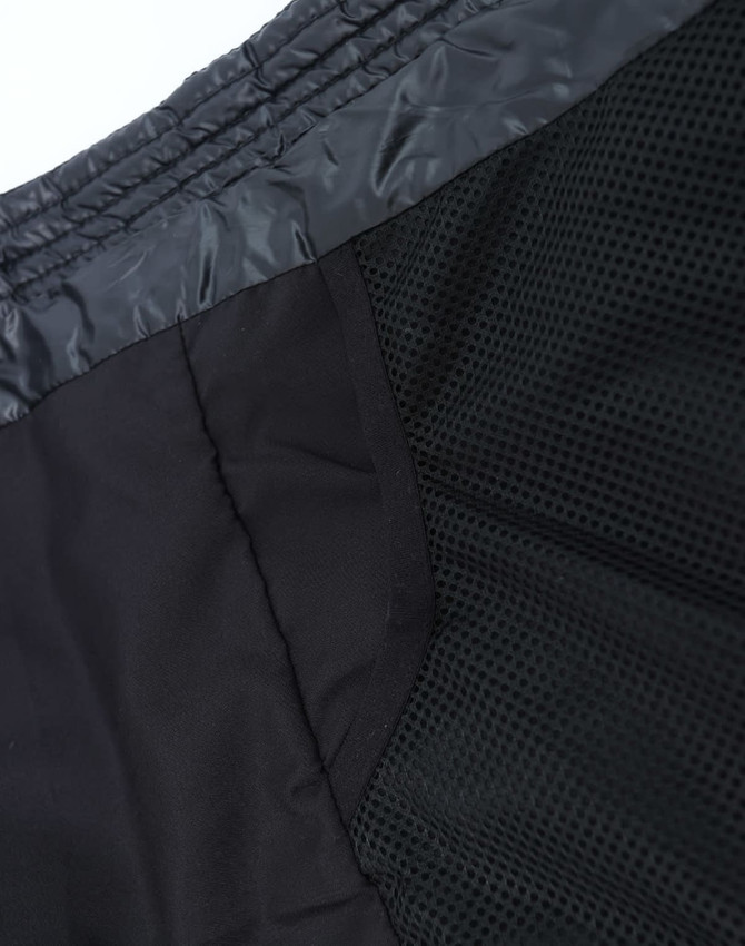 A lightweight hooded puffer jacket in black, featuring a mesh interior and a sleek design. It has a logo.
