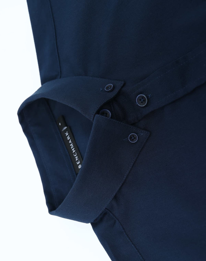 A navy cotton blend long-sleeve shirt with a buttoned collar and branding.