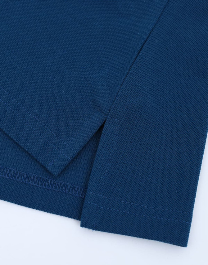 A close-up view of a navy blue cotton/poly pique polo shirt, highlighting the fabric texture and sleeve detail.